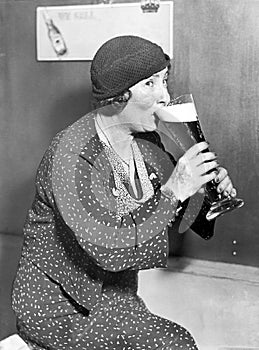 Woman drinking out of a big beer glass photo