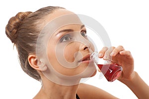 Woman drinking a red liquid