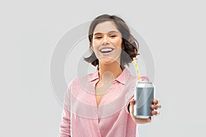 Woman drinking soda from can with paper straw