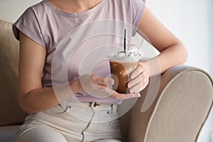Woman drinking tasty cold coffee at home