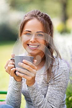 Woman drinking tea or coffee at summer garden