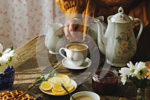 Woman drinking tea with milk and sugar.