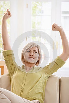 Woman drinking tea and stretching at home