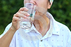 Woman drinking water, concept of taking care of her health by drinking enough water per day.