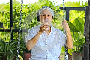 Woman drinking water, concept of taking care of your health by drinking enough water per day.