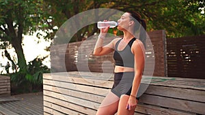 Woman drinking water after jogging