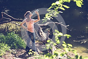 Woman drinking water by the lake