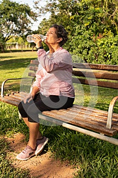 Woman drinking water. Outdoors in sunny day. Thirst, hydration, joy, vitality concept