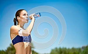 Woman drinking water after sport activities photo