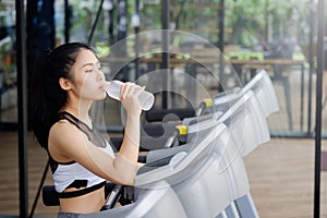 woman drinking water on wellness in sport gym.