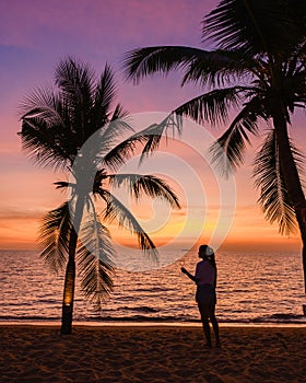 woman drinking wine and watchting the sunset on the beach of Pattaya Thailand