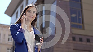 Woman drinks coffee holding an iPhone in her hand