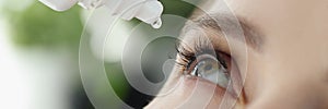 Woman drips eye drops into eye for allergies closeup