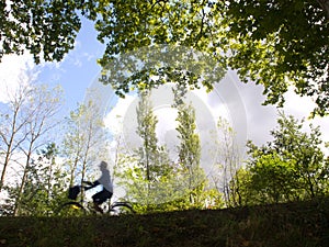 Woman drive bicicle on forest in spring time. photo