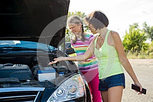 Woman driver with child on country road, near broken car