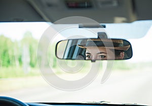 Woman driver eyes in the rearview mirror of her car