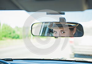 Woman driver eyes in the rearview mirror of her car