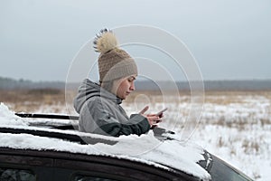 Woman driver got lost in a snow-covered field and looked out the hatch of a car