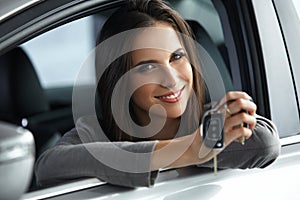 Woman Driver Holding Car Keys siting in Her New Car. photo