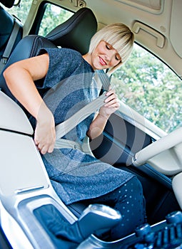 Woman driver putting safety belt