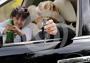 Woman driver reaching for bottle of booze