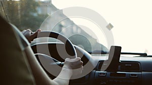 Woman driver`s hand on the steering wheel of a car. Woman traveling by transport. Woman driving a car