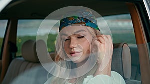 Woman driver sitting automobile in bandanna closeup. Portrait young girl hipster