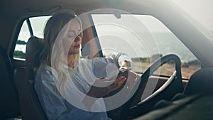 Woman driver texting telephone sitting retro car close up. Blonde focused screen