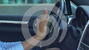 Woman driving automobile and listening to favorite music, good mood, happiness