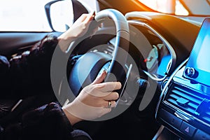 Woman driving car background with female hands holding steering wheel