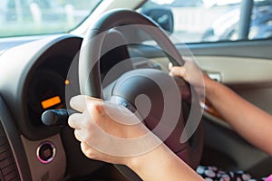 Woman driving a car and control steering wheel