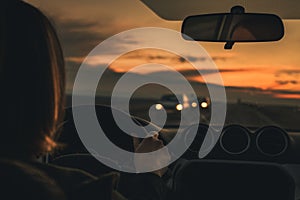 Woman driving car in dusk