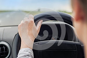 Woman driving car, hand on steering wheel