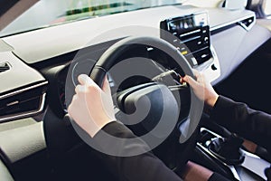 Woman driving a car, hands on steering wheel close-up.