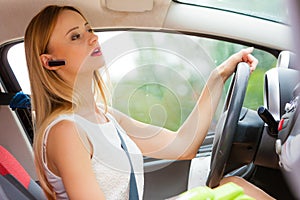 Woman driving car with headset