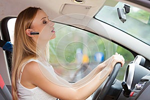 Woman driving car with headset