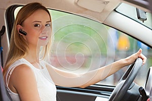 Woman driving car with headset