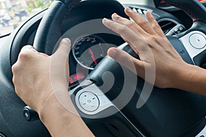 Woman driving car and honking.