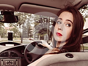 Woman driving car looking backwards