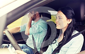 Woman driving car and man covering face with palm