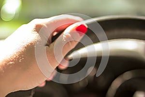 Woman driving a car with one hand holding the steering wheel