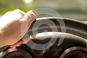 Woman driving a car with one hand holding the steering wheel