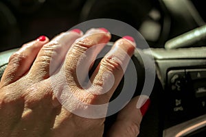 Woman driving a car with one hand holding the steering wheel