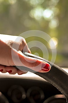 Woman driving a car with one hand holding the steering wheel