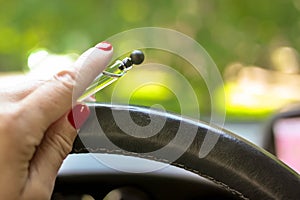 Woman driving a car with one hand holding the steering wheel and mobile phone with navigator map