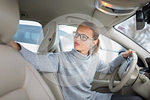 Woman driving a car - parking, going in reverse photo