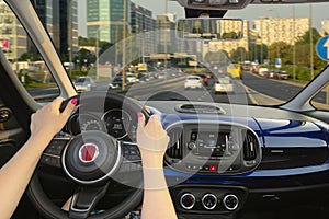 Woman driving a car on the road leading to the city