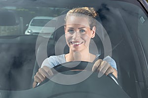 Woman driving car seen through windscreen