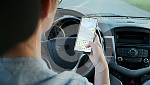Woman driving car texting message on mobile phone in motion, don't text and drive