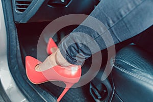 Woman driving a car in an unsafe manner with high-heel shoes